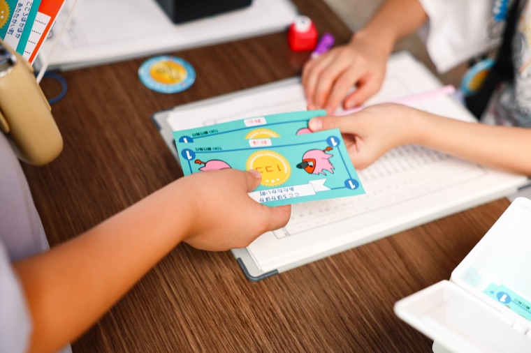 まちの通貨「ココ」を受け取って、ぜいきんをおさめるところ