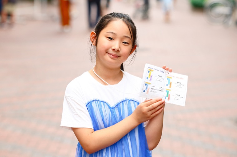 一日の終わりに、パスポートを手に笑顔を見せる子ども